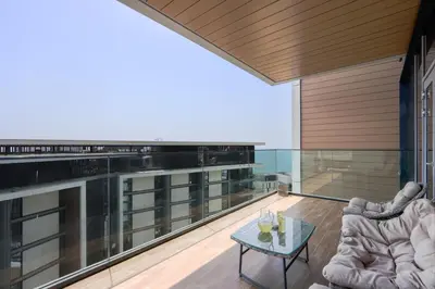 an open living room with a glass balcony with a table at Bluewaters Island - High-Floor 1 Bedroom Suite by Livbnb in Dubai