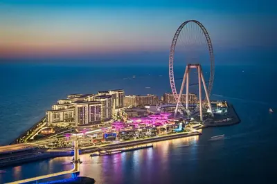 a view of a city with a ferris wheel at night at Bluewaters Island - High-Floor 1 Bedroom Suite by Livbnb in Dubai