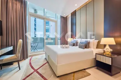 a bedroom with a bed and a desk and a window at Staycae Holiday Homes - Upper Crest in Dubai