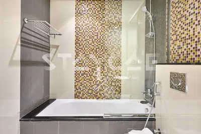 a bathroom with a tub and a glass shower at Staycae Holiday Homes - Upper Crest in Dubai