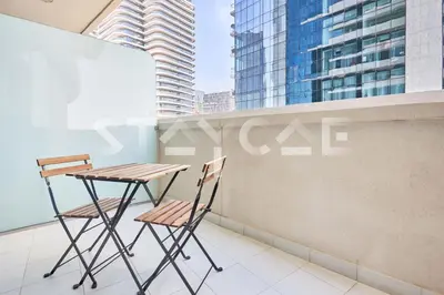 a table and chairs on a balcony with skyscrapers at Staycae Holiday Homes - Upper Crest in Dubai