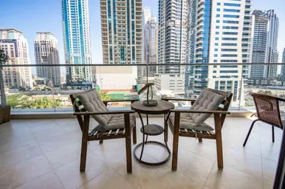 a balcony with a table and chairs and a view of a city at Stylish and Sleek 1 Bed + Study near the JBR beach in Dubai