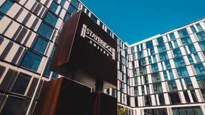 a sign in front of a tall building at Staybridge Suites Dubai Al-Maktoum Airport by IHG in Dubai