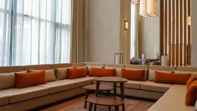 a living room with a large couch with orange pillows at Staybridge Suites Dubai Al-Maktoum Airport by IHG in Dubai
