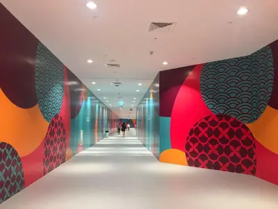 a hallway with brightly colored walls and a hallway with people walking down it at Frank Porter - Mon Reve in Dubai