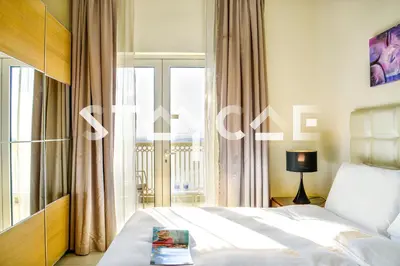 a bedroom with a bed and a large window at Staycae Holiday Homes - Suburbia in Dubai