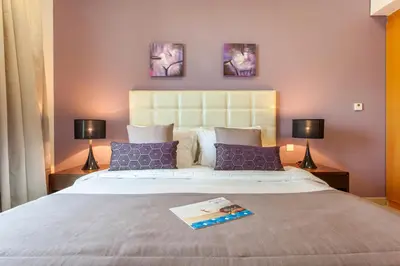 a bedroom with a large bed with two lamps at Staycae Holiday Homes - Suburbia in Dubai