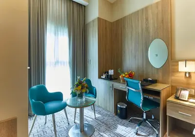 a room with a desk and two chairs and a table at Rose Plaza Hotel Al Barsha in Dubai
