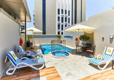 a patio with chairs and a swimming pool on a building at Rose Plaza Hotel Al Barsha in Dubai