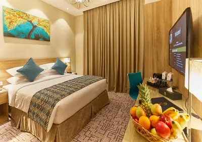 a hotel room with a bed and a bowl of fruit at Rose Plaza Hotel Al Barsha in Dubai