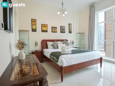 a bedroom with a bed and a glass table at HiGuests - Deluxe Apartment With Balcony and Amazing Views in Dubai