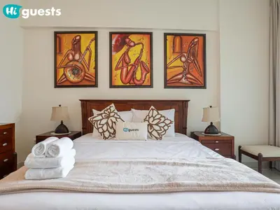 a bedroom with a bed with four paintings on the wall at HiGuests - Deluxe Apartment With Balcony and Amazing Views in Dubai