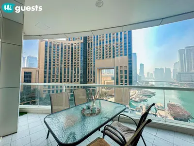 a glass table and chairs on a balcony with a view at HiGuests - Deluxe Apartment With Balcony and Amazing Views in Dubai