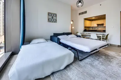 two beds in a room with a kitchen and a table at 5 star Sparkle Tower by Swarovski, Dubai Marina in Dubai