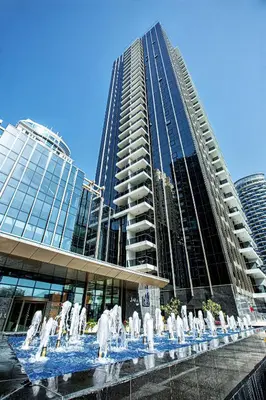 a fountain in front of a building with a tall building at 5 star Sparkle Tower by Swarovski, Dubai Marina in Dubai