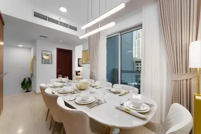 a white dining room with a white table and chairs at Maison Privee - Exclusive Duplex Villa with Panoramic Terrace Overlooking Burj Khalifa in Dubai
