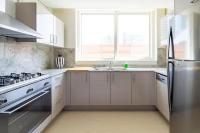 a kitchen with white cabinets and a stainless steel refrigerator at Frank Porter - Mon Reve in Dubai