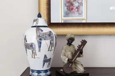 a statue of a man playing a guitar next to a vase at Frank Porter - Mon Reve in Dubai