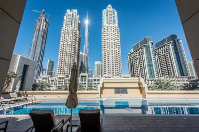 a pool with chairs and an umbrella in front of a city at Close to Burj Khalifa & Dubai Mall with Relaxing Balcony, Claren Tower 1, Downtown Dubai by Deluxe Holiday Homes in Dubai