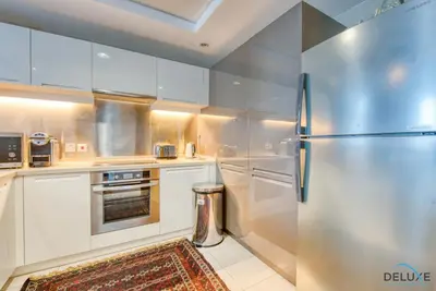 a kitchen with white cabinets and a stainless steel refrigerator at Close to Burj Khalifa & Dubai Mall with Relaxing Balcony, Claren Tower 1, Downtown Dubai by Deluxe Holiday Homes in Dubai