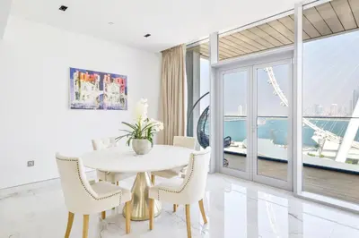 a white dining room with a table and chairs at Contemporary and Spacious 2 BR in Bluewaters Island in Dubai