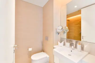 a bathroom with a sink and a toilet and a mirror at Contemporary and Spacious 2 BR in Bluewaters Island in Dubai
