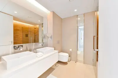 a white bathroom with a sink and a toilet at Posh 2 BR Oceanfront Apt in the Heart of Bluewaters Island in Dubai