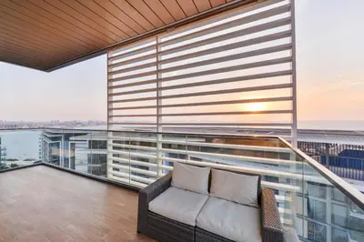 a balcony with a couch and a view of the ocean at Posh 2 BR Oceanfront Apt in the Heart of Bluewaters Island in Dubai