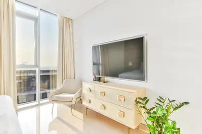 a living room with a television and a chair at Posh 2 BR Oceanfront Apt in the Heart of Bluewaters Island in Dubai