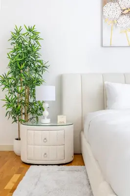 a bedroom with a bed and a table with a plant at Island Paradise - Stylish 1BR on Bluewaters Island in Dubai