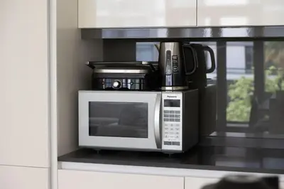 a microwave sitting on a shelf in a kitchen at Island Paradise - Stylish 1BR on Bluewaters Island in Dubai