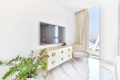 a living room with a television on a dresser at Lavish & Equipped oceanfront 2 BR facing Ain Dubai in Dubai