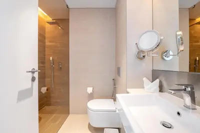 a bathroom with a toilet and a sink and a mirror at Lavish & Equipped oceanfront 2 BR facing Ain Dubai in Dubai