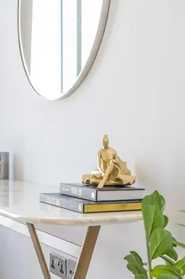 a stack of books on a table with a mirror at Spectacular 3 BR condo with maids room facing the Dubai Eye in Dubai