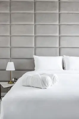 a bedroom with a white bed with a large headboard at Spectacular 3 BR condo with maids room facing the Dubai Eye in Dubai