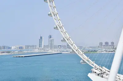 a bridge over the water with a city in the background at Spectacular 3 BR condo with maids room facing the Dubai Eye in Dubai