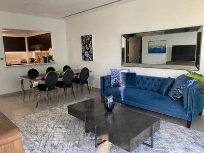a living room with a blue couch and a table at BELLEVUE Downtown Dubai in Dubai