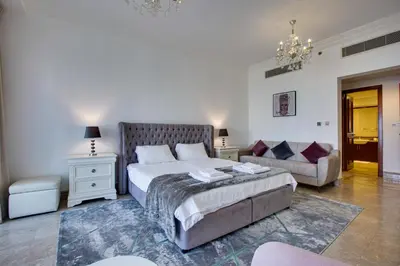 a bedroom with a large bed and a couch at Harmony Vacation Homes - South Residence in Dubai