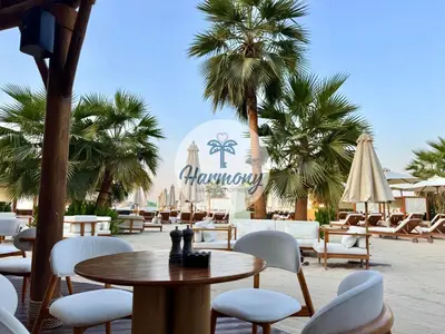a restaurant with a table and chairs and palm trees at Harmony Vacation Homes - South Residence in Dubai