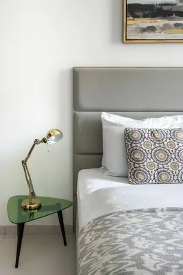 a lamp on a table next to a bed at Frank Porter - Panoramic Tower in Dubai