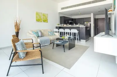 a living room and kitchen with a couch and chairs at Frank Porter - Panoramic Tower in Dubai