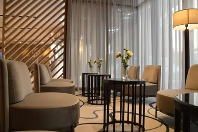a waiting room with chairs and tables and flowers at Beach Walk Hotel Jumeirah in Dubai