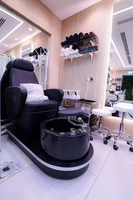 a salon with a black reclining chair and tables at Beach Walk Hotel Jumeirah in Dubai