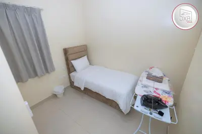 a small bedroom with a bed and a table at 5 bedroom Villa - Dubai Hills in Dubai