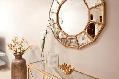 a mirror on a table with a vase and flowers at Elite Royal Apartment - Onyx in Dubai