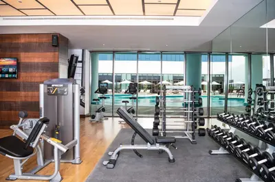a gym with cardio equipment and a swimming pool at Al Jaddaf Rotana Dubai in Dubai