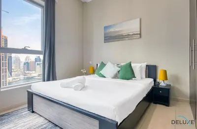 a bedroom with a large bed with a large window at Overlooking Marina Canal 1BR Close to Mall, Promenade & Beach, Bay Central 1, Dubai Marina by Deluxe Holiday Homes in Dubai