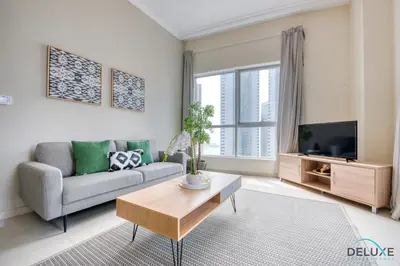 a living room with a couch and a tv at Overlooking Marina Canal 1BR Close to Mall, Promenade & Beach, Bay Central 1, Dubai Marina by Deluxe Holiday Homes in Dubai