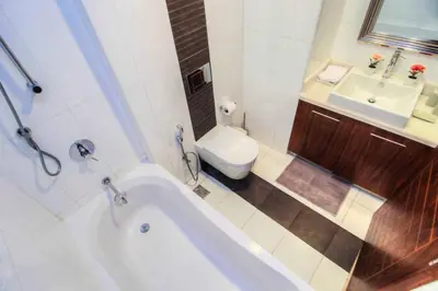 a bathroom with a tub and a sink and a toilet at Durrani Homes - Luxurious Studio near Dubai Mall with pool view in Dubai