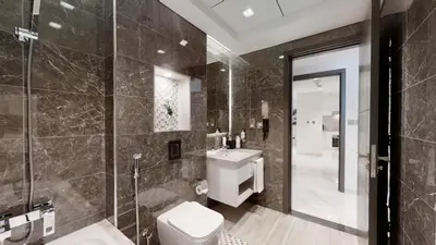 a bathroom with a toilet and a sink and a shower at SUHA Mina Rashid Hotel Apartments in Dubai